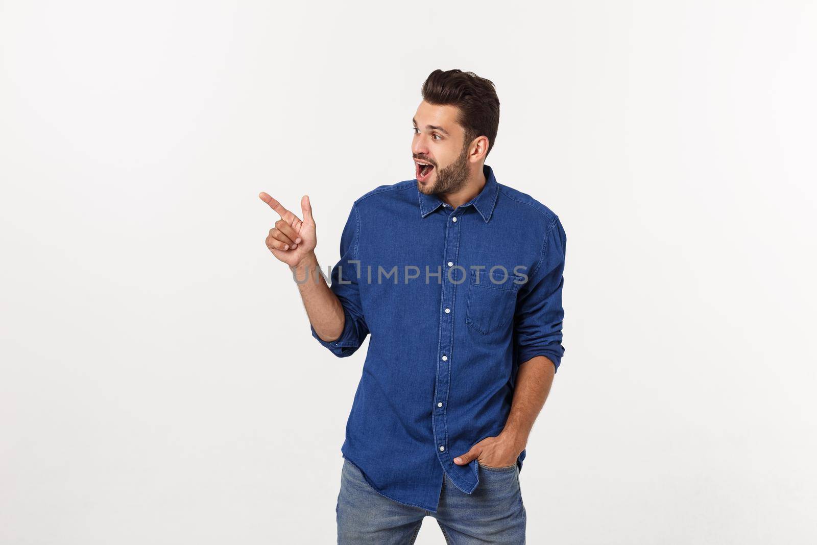 Man pointing showing copy space isolated on white background. Casual handsome Caucasian young man