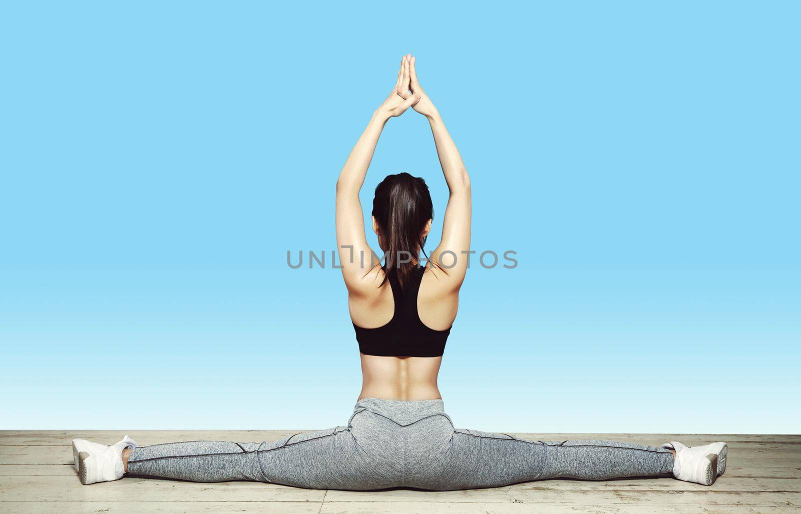 Beautiful young asian Woman Working Out, doing Pilates Exercise in Sportswear. Splits with Yoga Asana, Stretching. Healthy lifestyle, perfect shapes