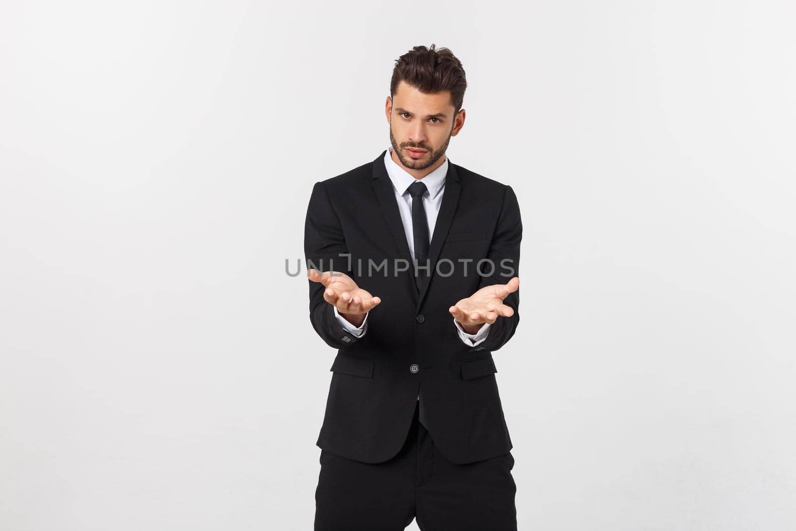 Portrait of confident mature businessman in formals standing isolated over white background by Benzoix