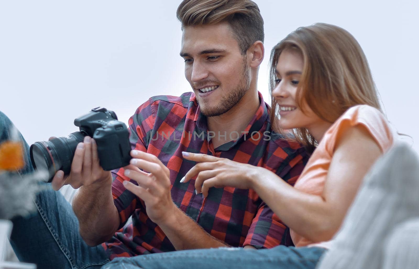 modern young couple checks the photos on the camera. photo blurred background and has copy space.