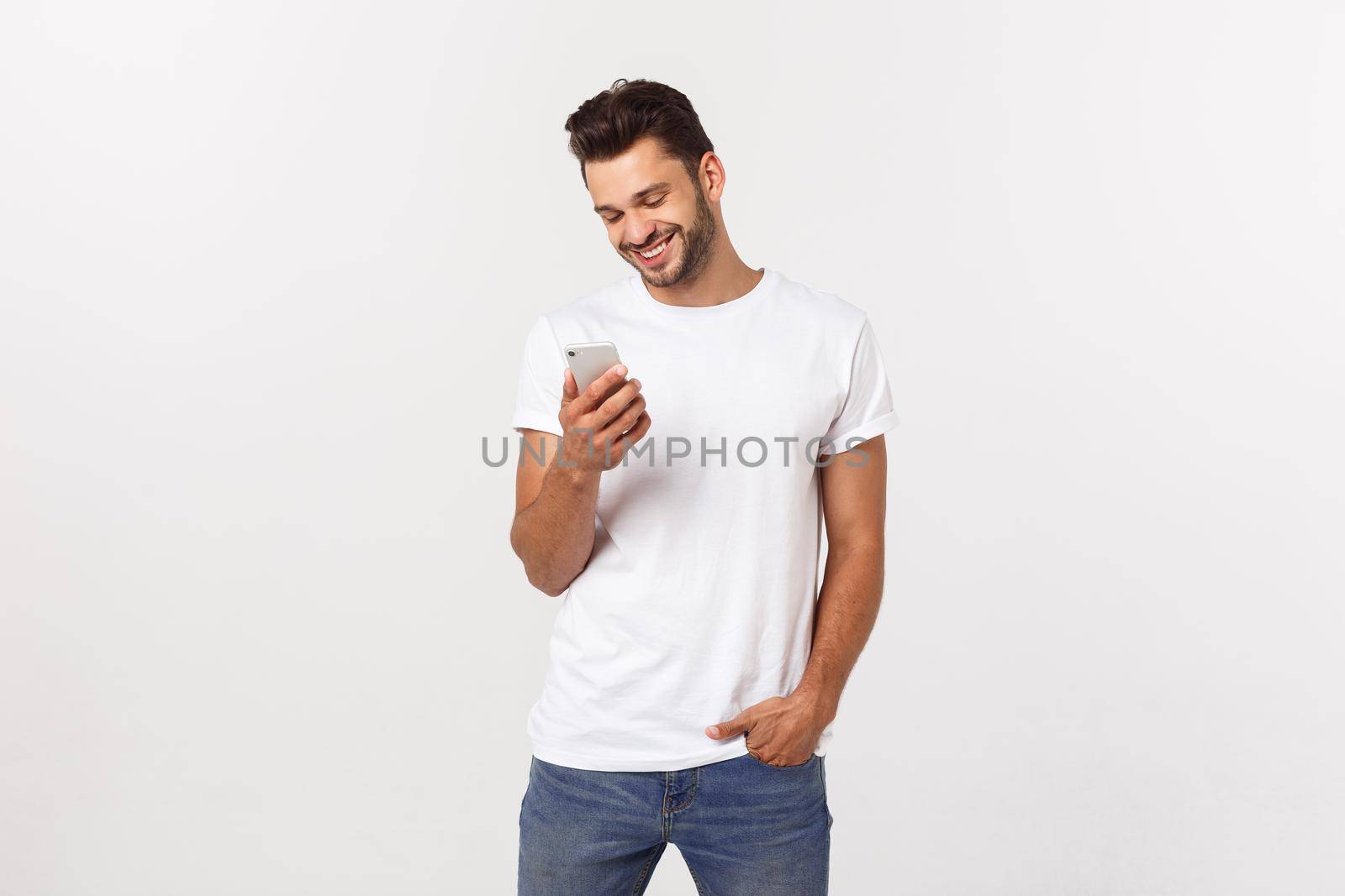 Happy casual man playing on smartphone over gray background by Benzoix