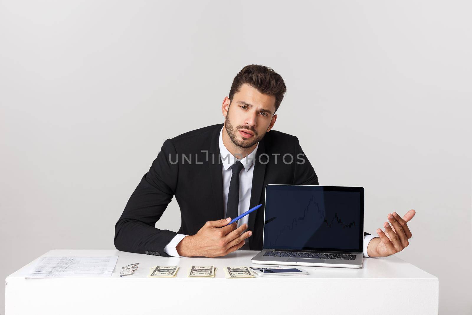 businessman sitting at desk point finger at isolated white laptop screen with empty copy space, handsome young business man.