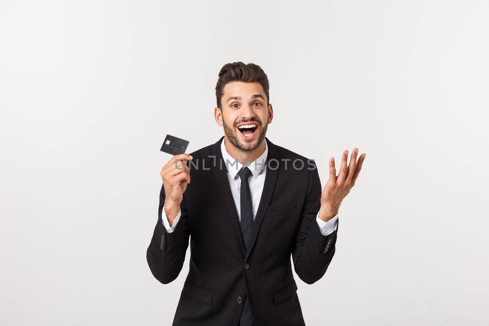 Surprised, speechless and impressed handsome caucasian businessman in classic suit showing credit card, say wow, standing white background astonished by Benzoix