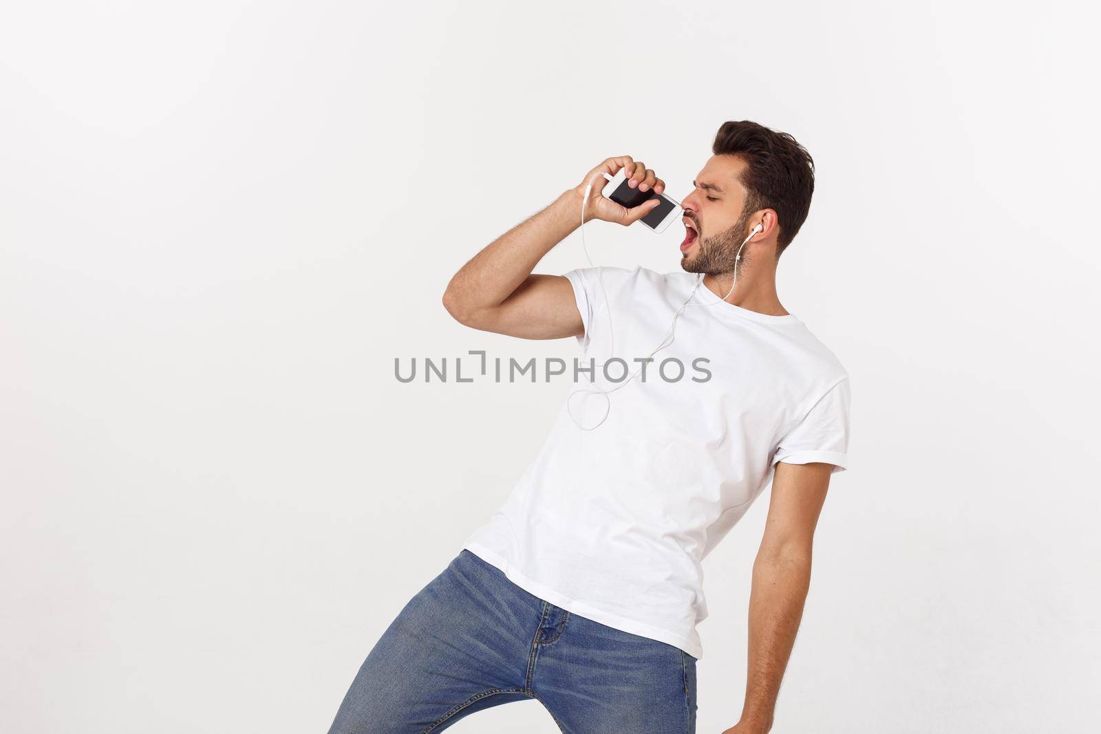 Casual handsome man dancing with mobile phone isolated on white background by Benzoix