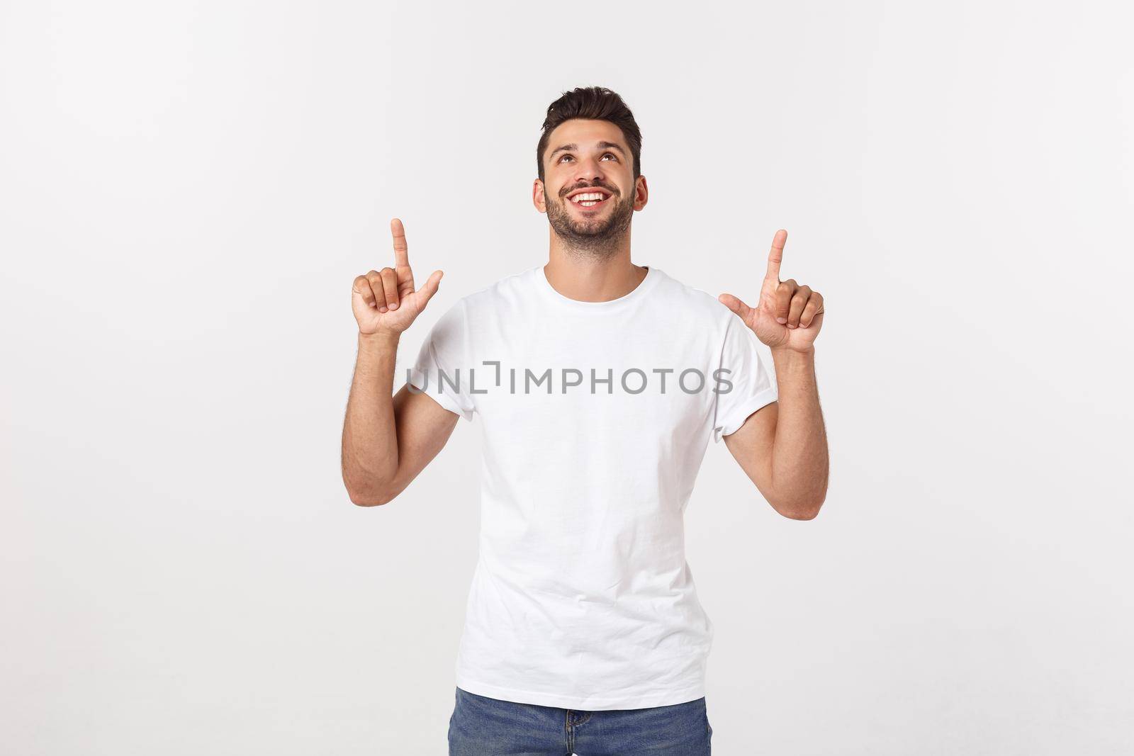 Man pointing showing copy space isolated on white background. Casual handsome Caucasian young man. by Benzoix