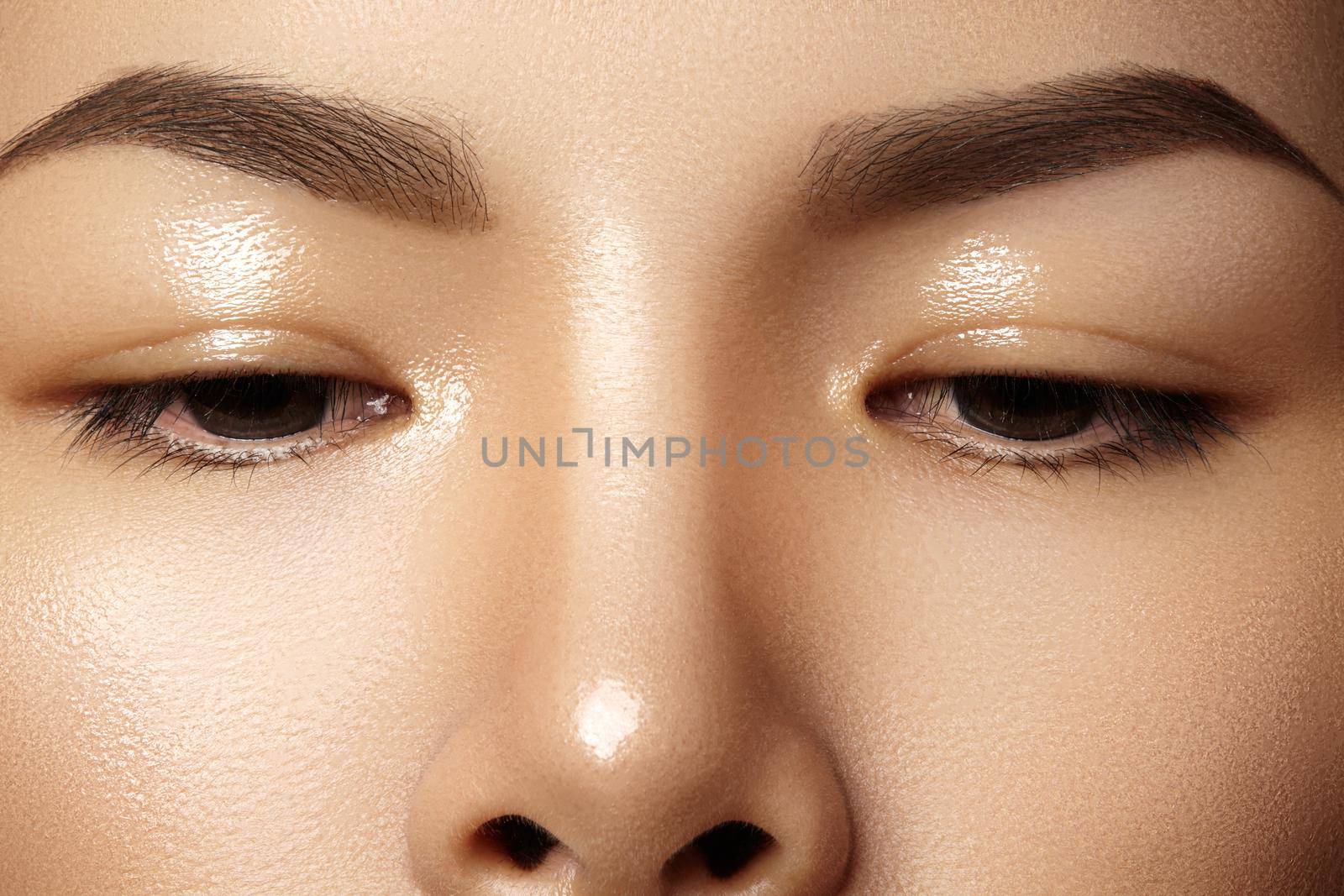 Beautiful female eye with clean skin, daily fashion makeup. Asian model face. Perfect shape of eyebrow. Wet gel for care skin