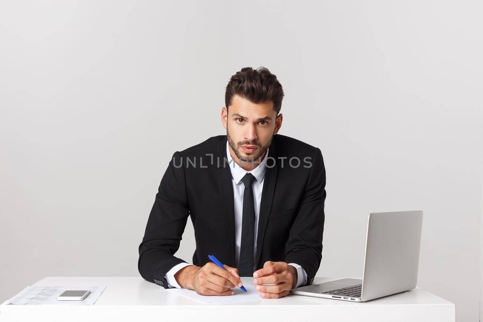 Happy young businessman working at desk at office, smiling. by Benzoix