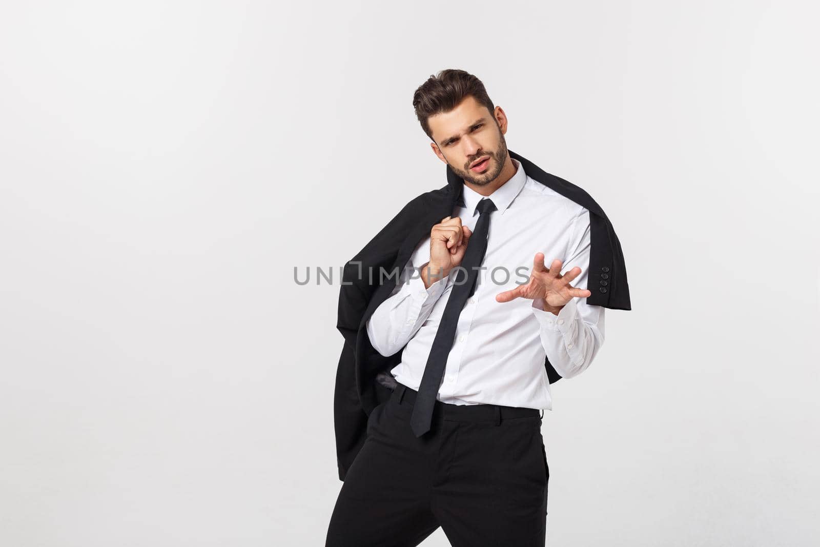 Portrait of confident handsome man holding his suit, isolated on white background.