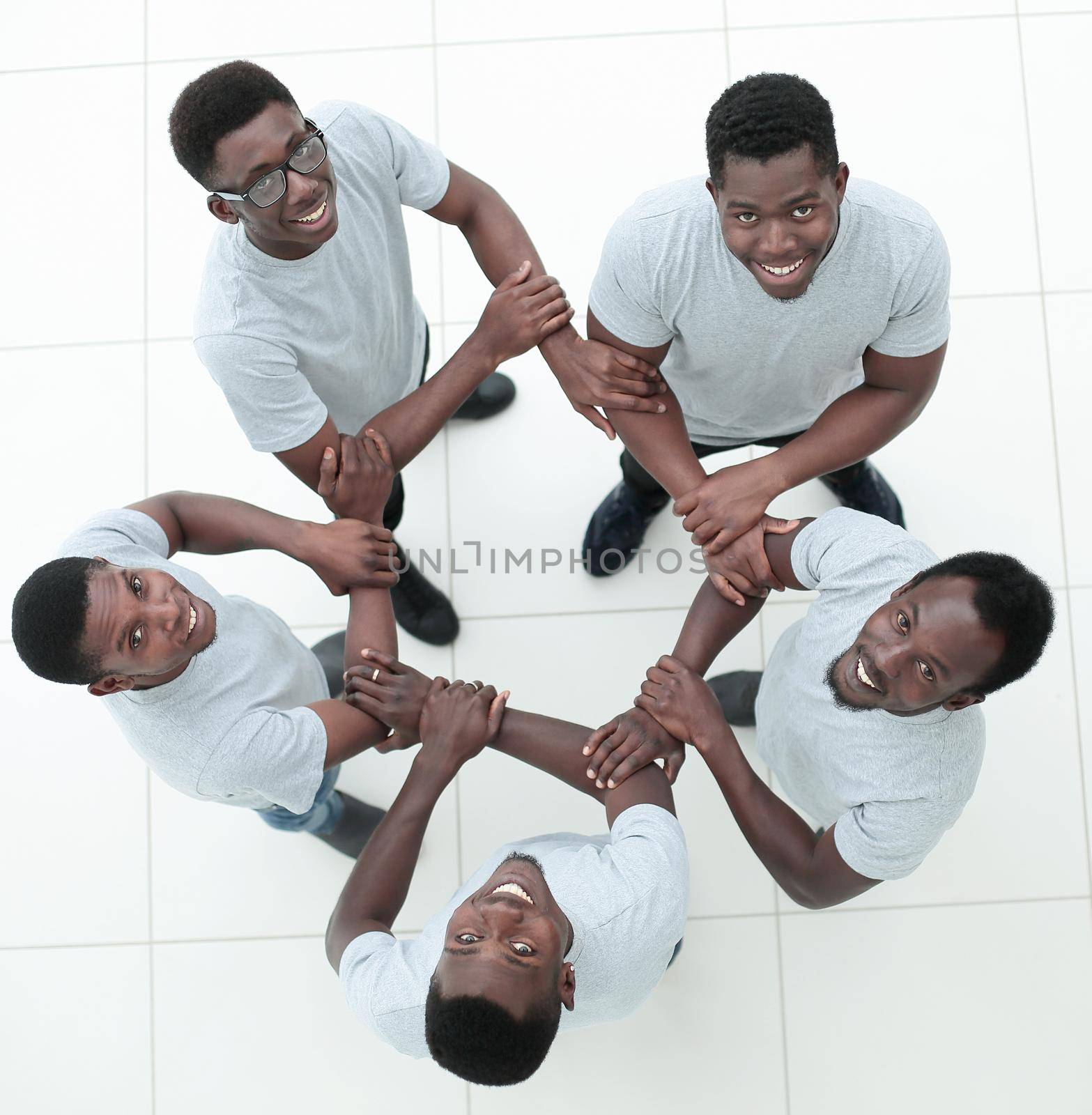 top view. a group of guys make a circle of hands. isolated on white