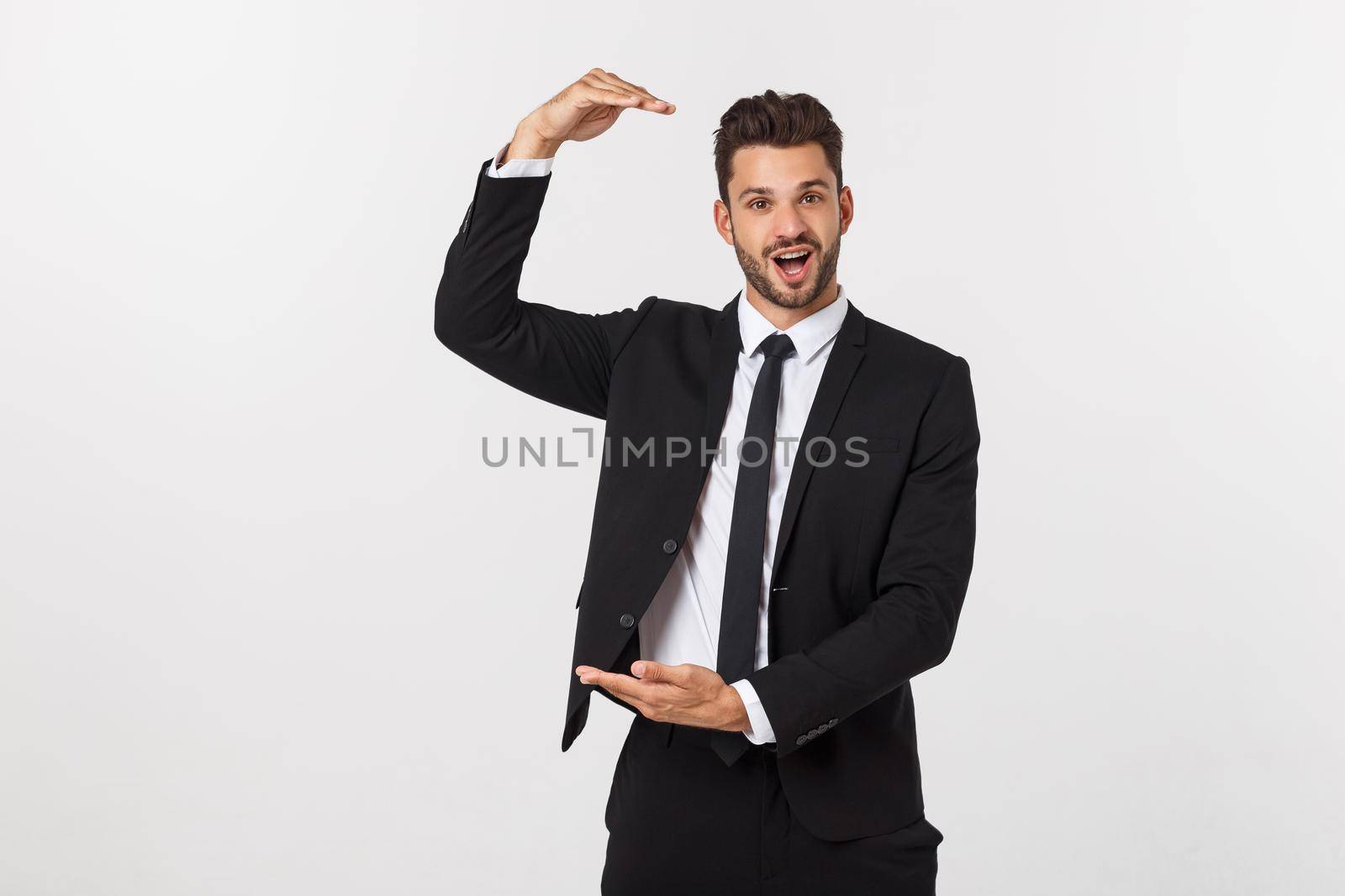 A man shows with his hands a large size on an isolated background.