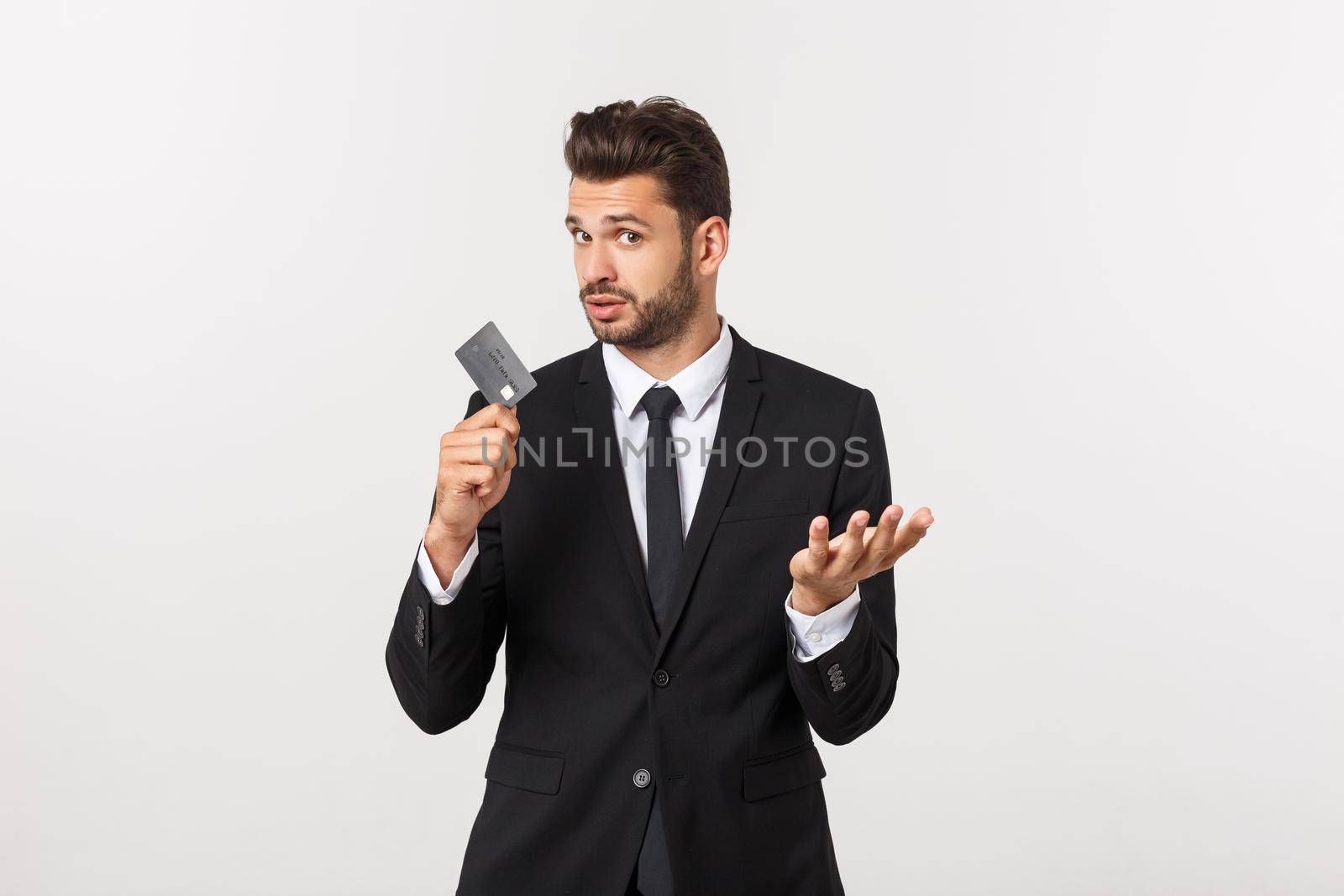 Surprised, speechless and impressed handsome caucasian businessman in classic suit showing credit card, say wow, standing white background astonished.