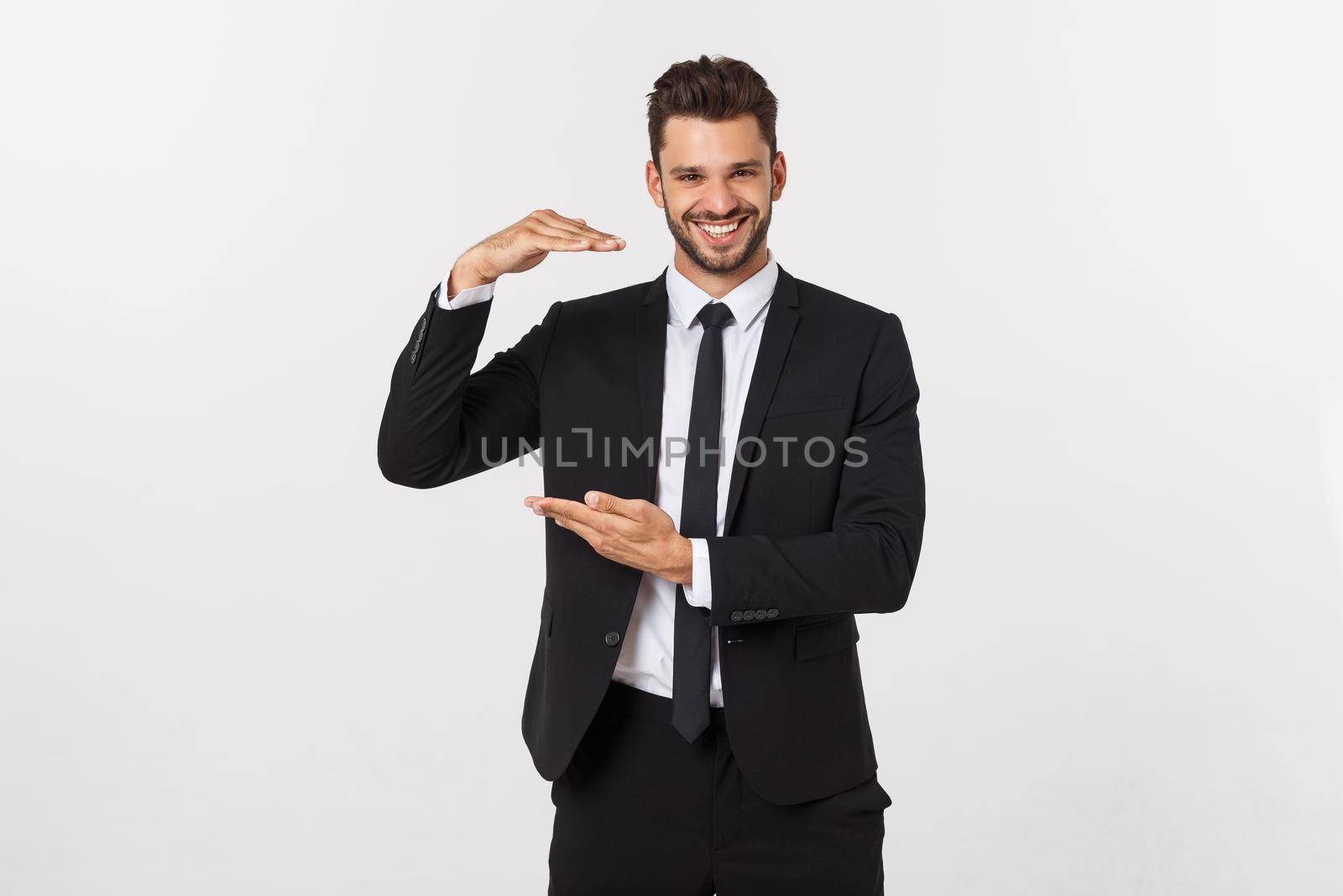 A man shows with his hands a large size on an isolated background by Benzoix