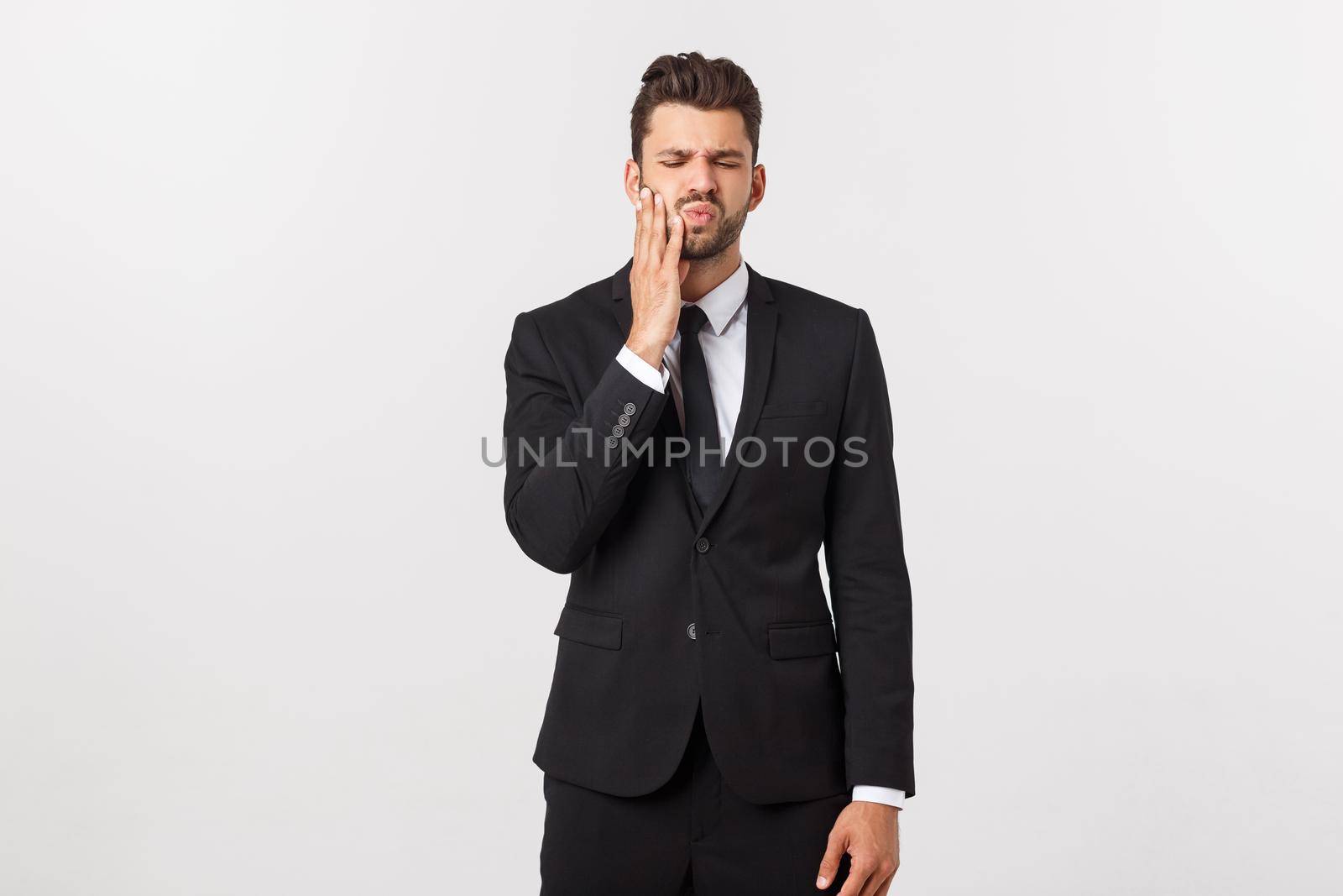 Strong toothache - businessman in pain. Portrait young adult businessman isolated against white background. Short-haired male