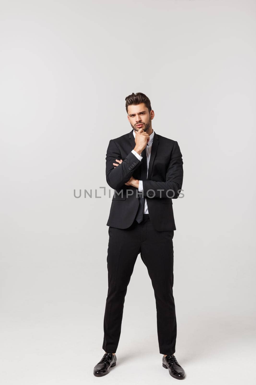 Photo of an attractive businessman with his arms crossed and smiling over a white background