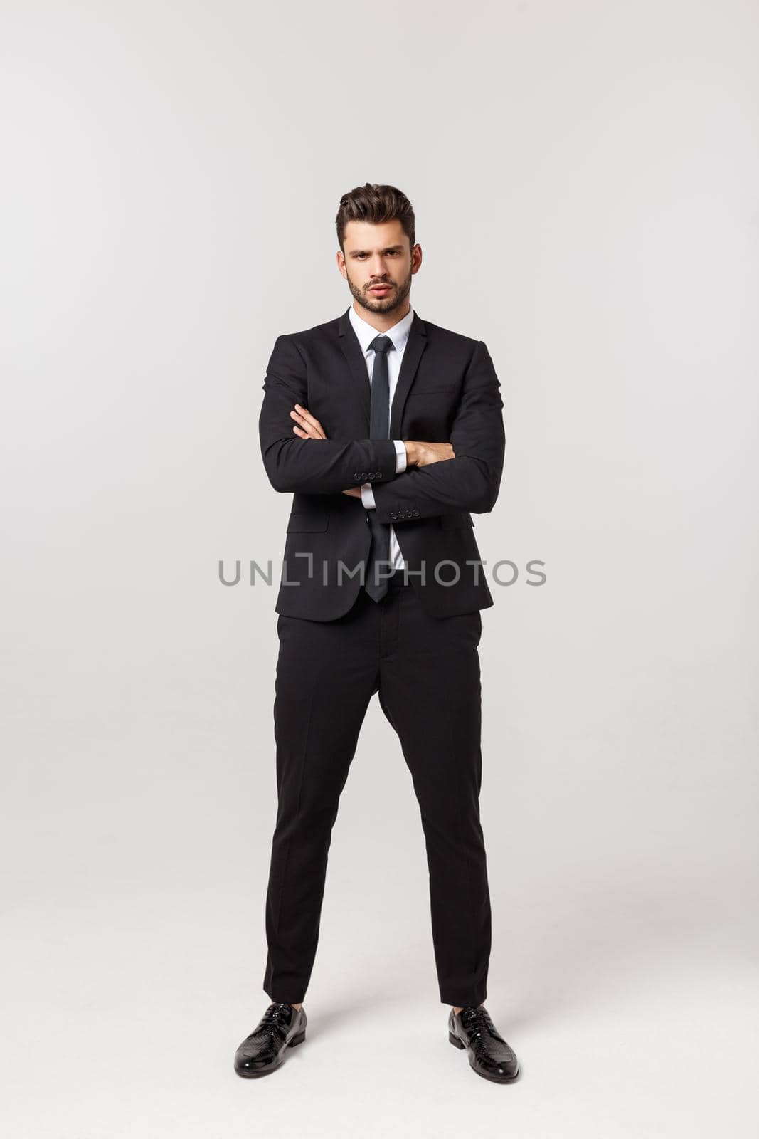 Photo of an attractive businessman with his arms crossed and smiling over a white background