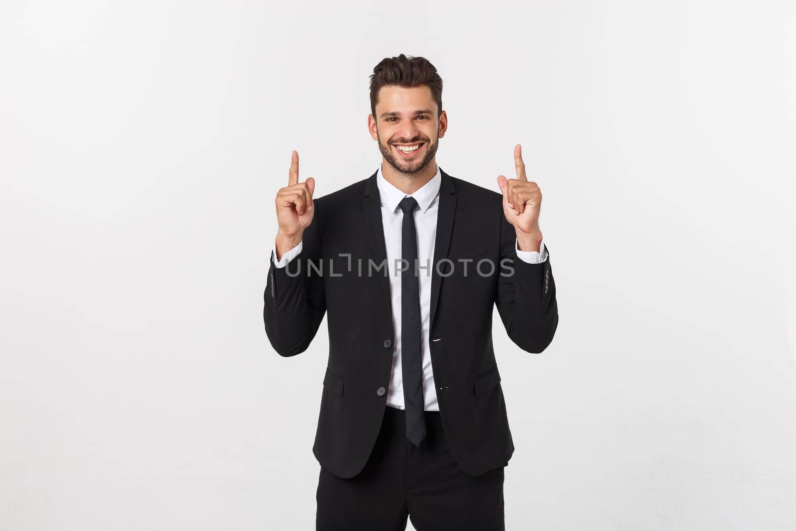 Young businessman celebrating his success over gray background