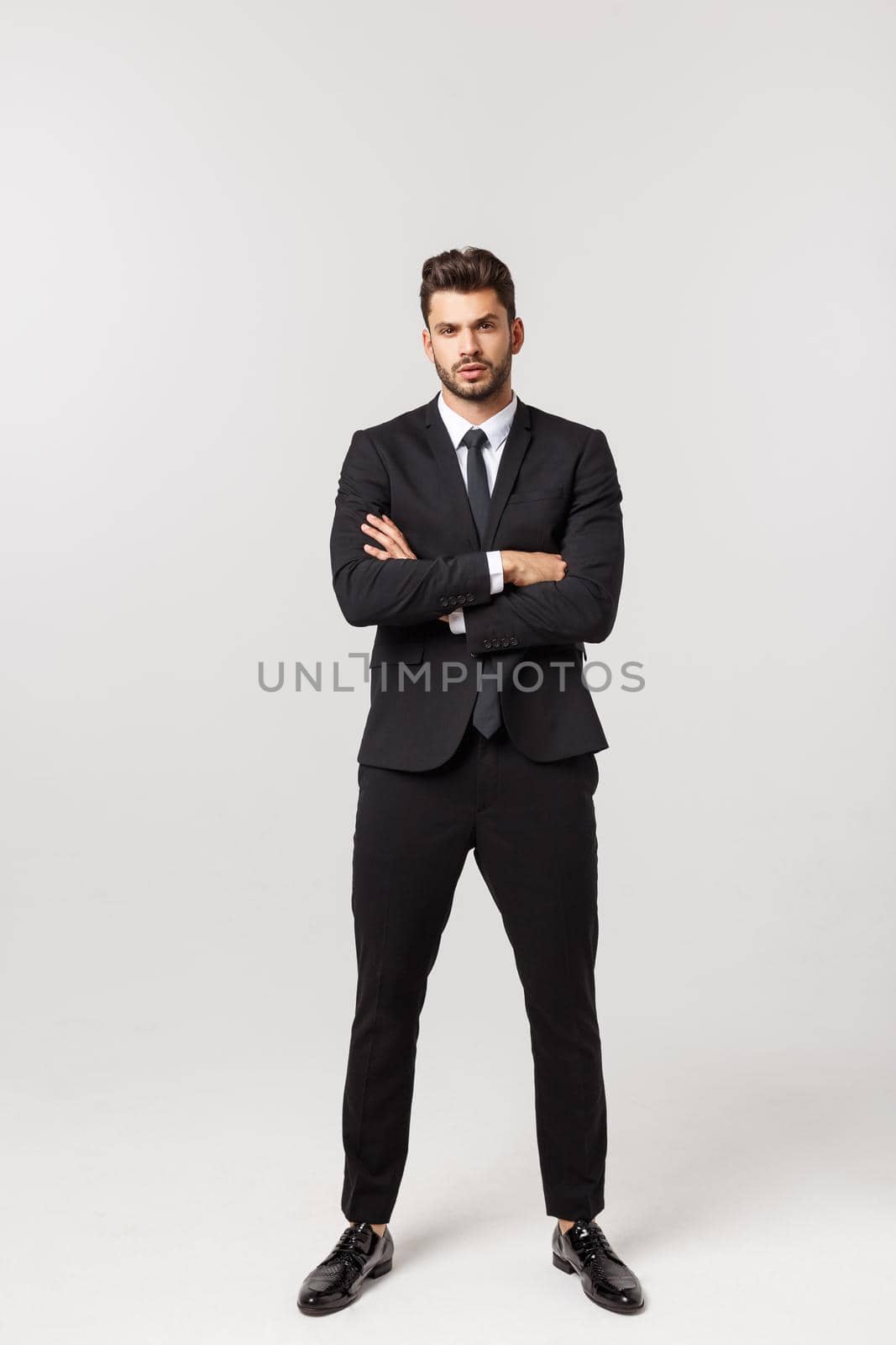 Photo of an attractive businessman with his arms crossed and smiling over a white background