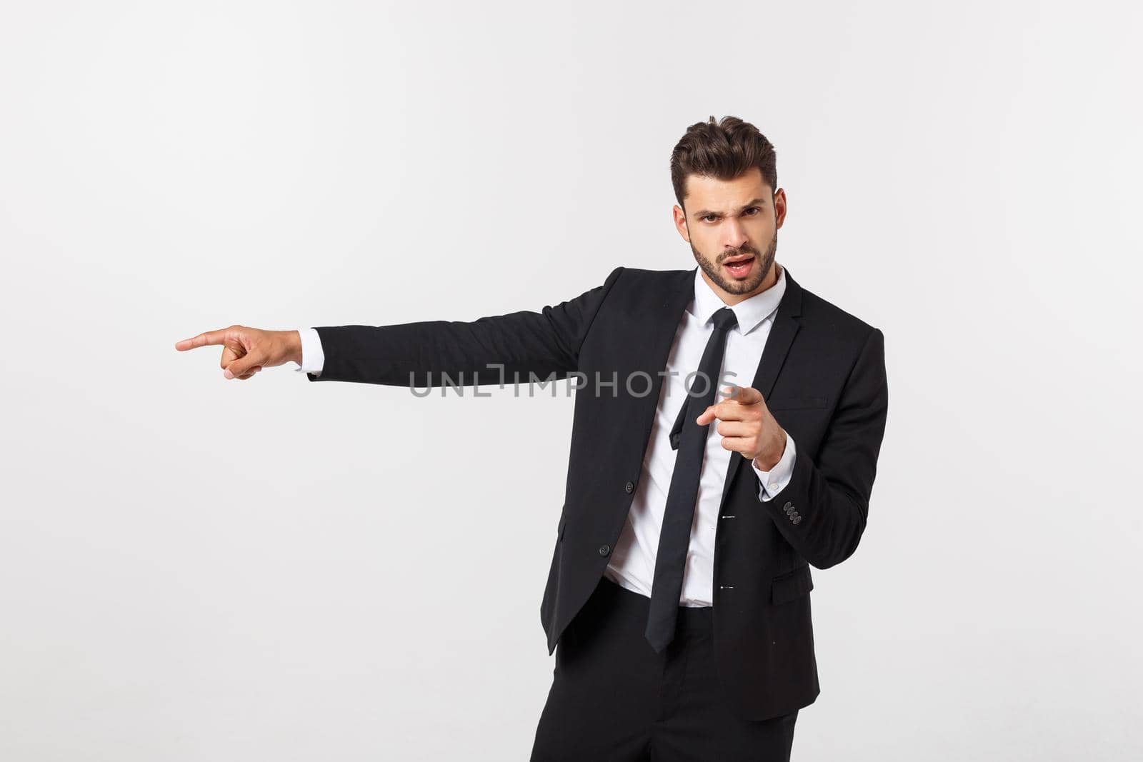 Portrait businessman angry and pointing finger at you over isolated white background by Benzoix