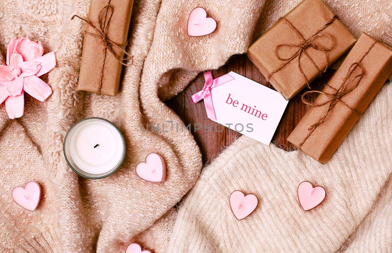 Cozy Winter Flatlay with Heart Shape Candles, Gifts and Warm Knitted Plaid. Pink Still life for St. Valentine's Day. Relax in Weekend for Woman. Hygge Style.