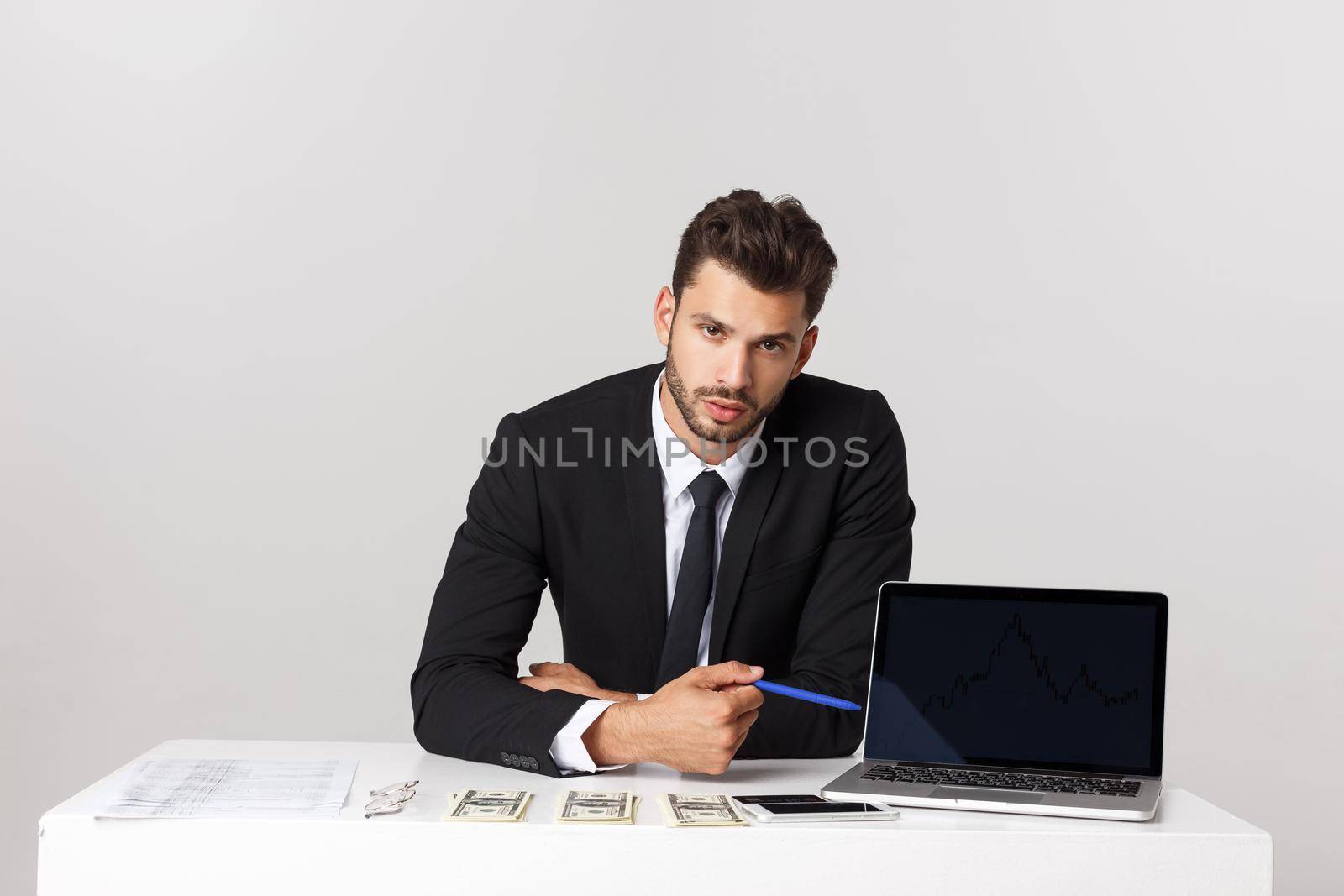 businessman sitting at desk point finger at isolated white laptop screen with empty copy space, handsome young business man.