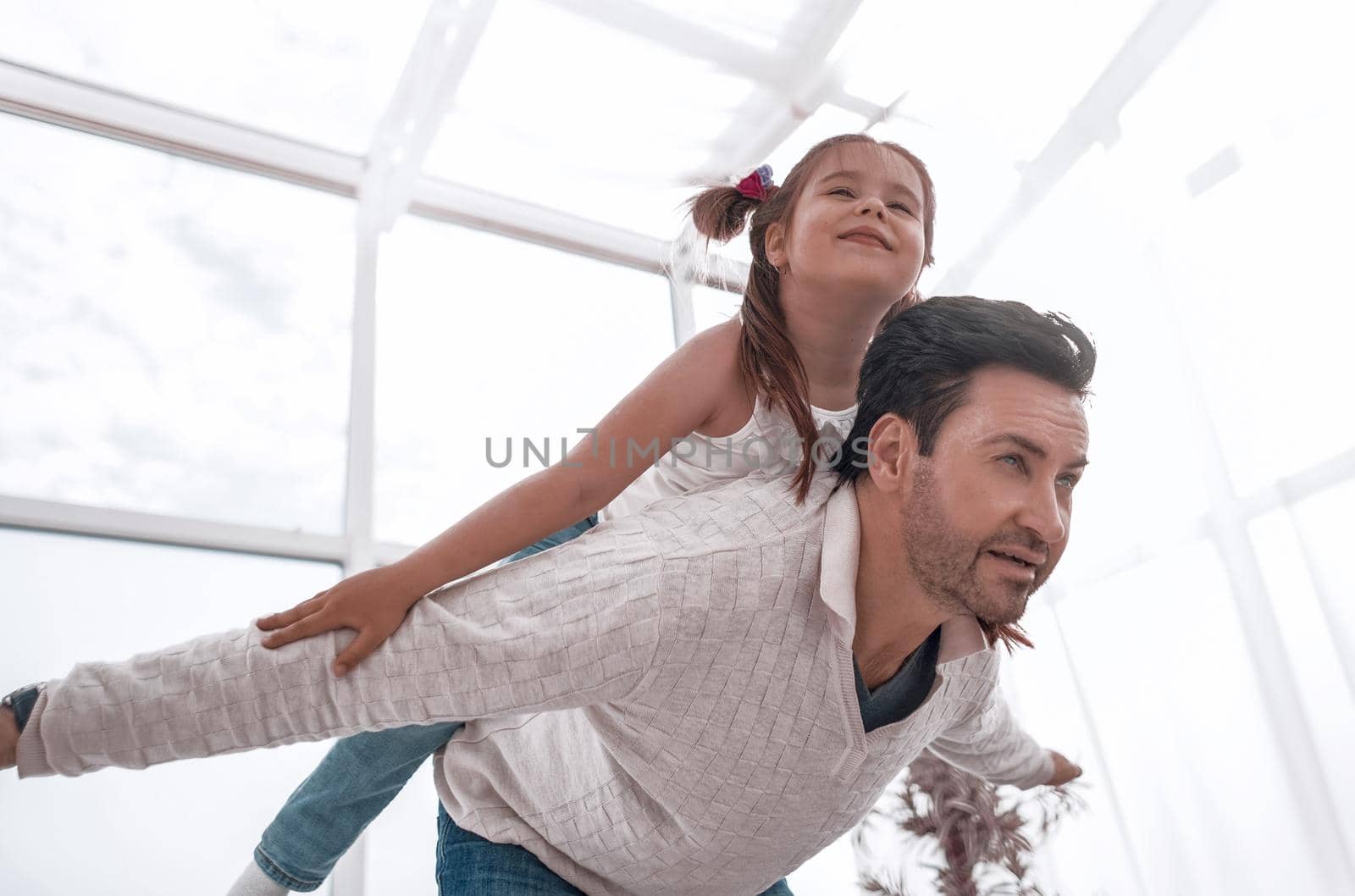 Happy father playing with his daughter at home.the concept of parenthood