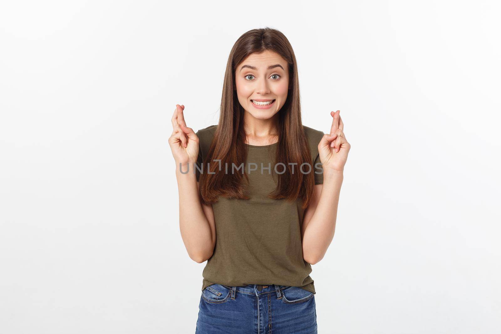 Closeup portrait hopeful beautiful woman crossing her fingers, open eyes, hoping, asking best isolated on gray wall background