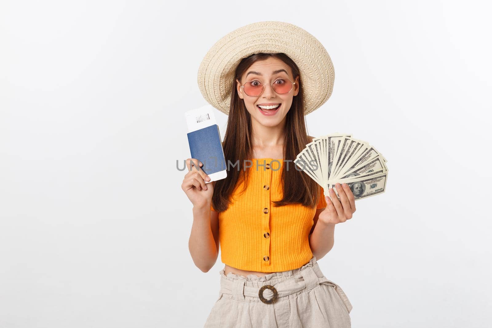Portrait of cheerful, happy, laughing girl with hat on head, having money fan and passport with tickets in hands, isolated on white background by Benzoix