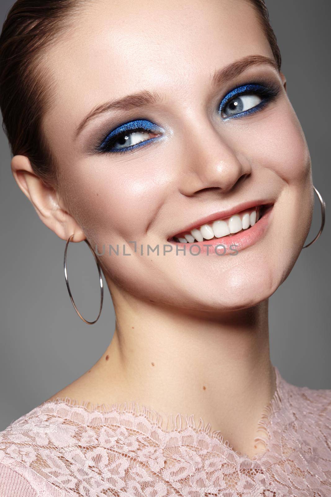 Beautiful Woman with Professional Blue Makeup. Celebrate Style Eye Make-up and Shine Skin. Smiling Fashion Model. Beautifil Happy Smile