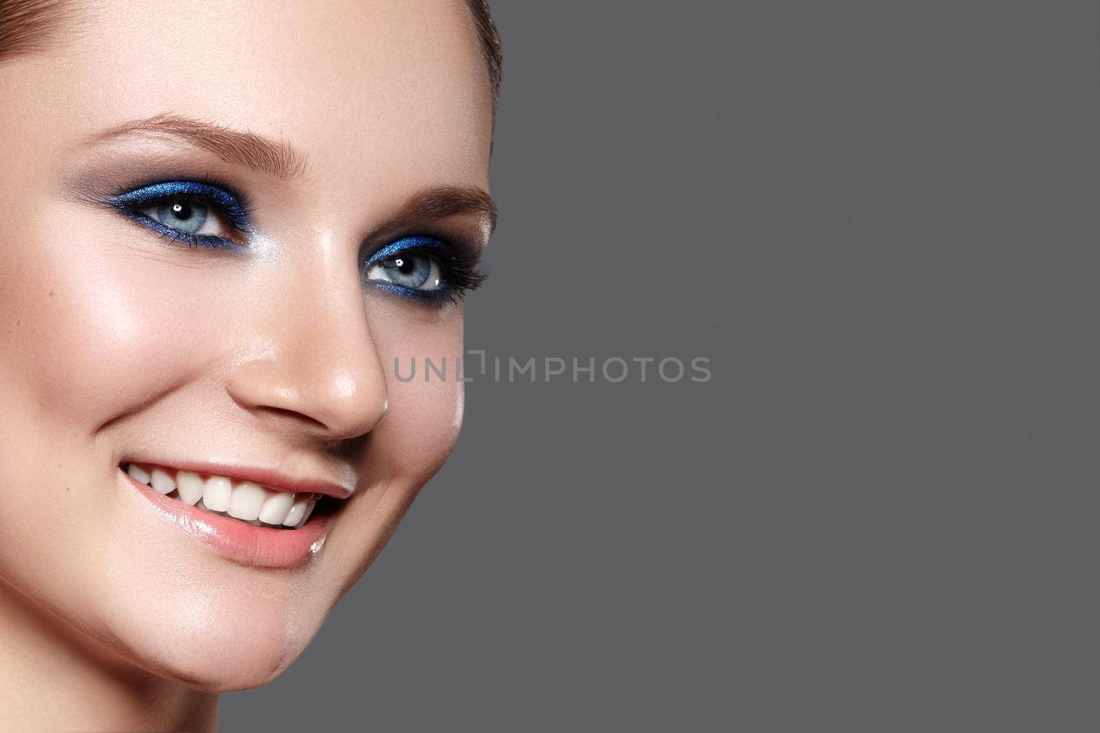 Beautiful Woman with Professional Blue Makeup. Celebrate Style Eye Make-up and Shine Skin. Smiling Fashion Model. Beautifil Happy Smile