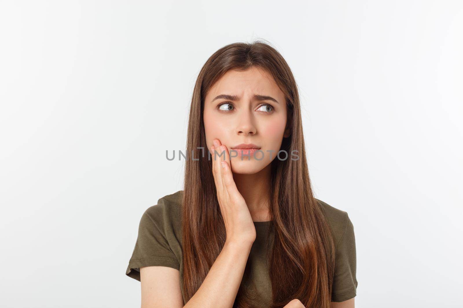 Teen woman pressing her bruised cheek with a painful expression as if she is having a terrible tooth ache.