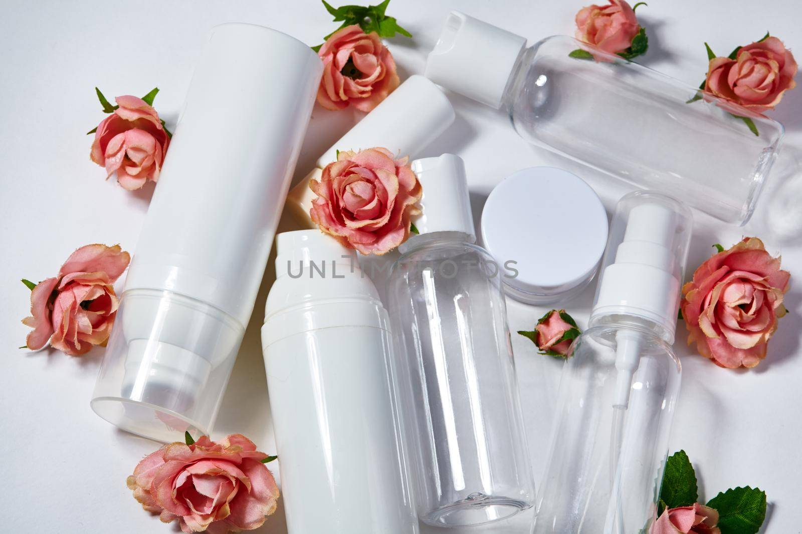 White cosmetic bottles on white background. Wellness, spa and body care bottles collection with spring parfume flowers. Beauty treatment, bathroom set.