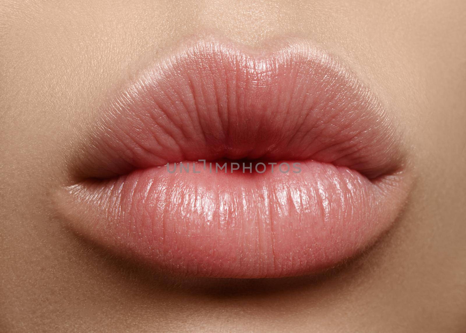 Close-up perfect natural lip makeup beautiful female mouth. Plump sexy full lips. Macro photo face detail. Perfect clean skin, fresh lip make-up. Beautiful spa tender lips