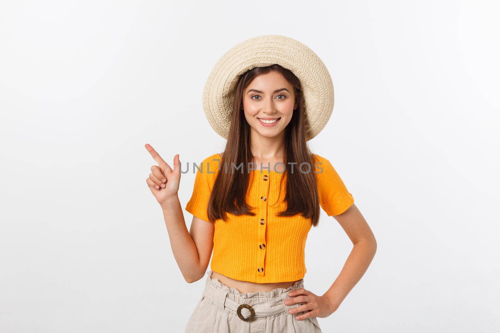 Teenager girl on summer vacation surprised and pointing finger on copy space over isolated white background. by Benzoix