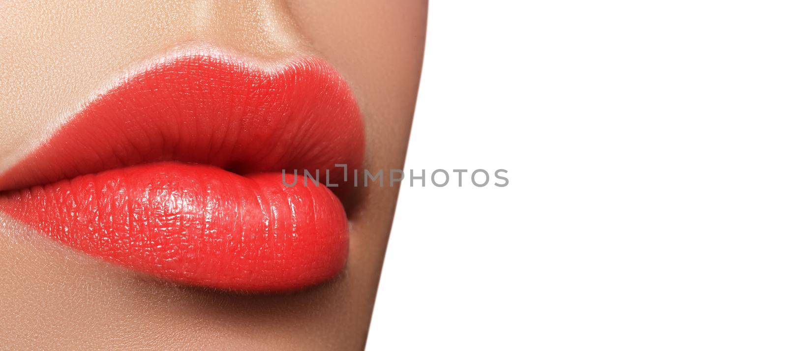 Close-up macro shot of female mouth. Sexy Glamour red lips Makeup with sensuality gesture. Juicy gloss lipstick. Full lips