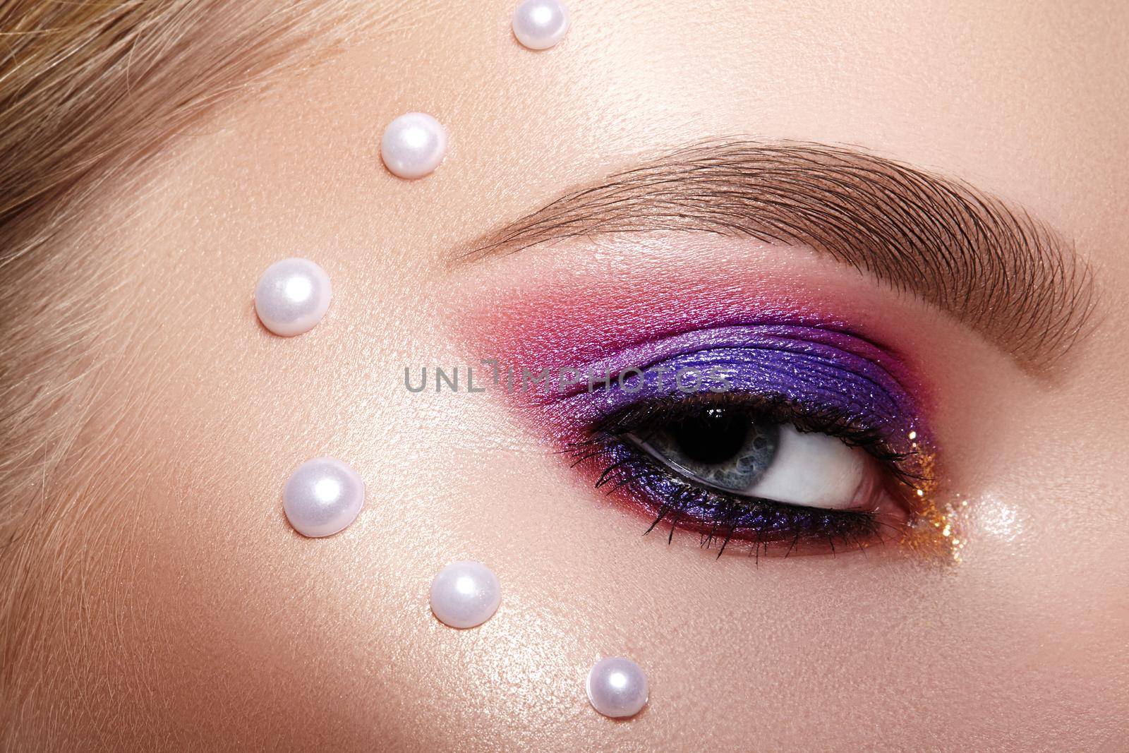 Closeup Macro of Woman Face with Purple and Pink Eyes Make-up with Perls Decor. Fashion Celebrate Makeup, Glowy Clean Skin, perfect Shapes of Brows. Shiny Simmer