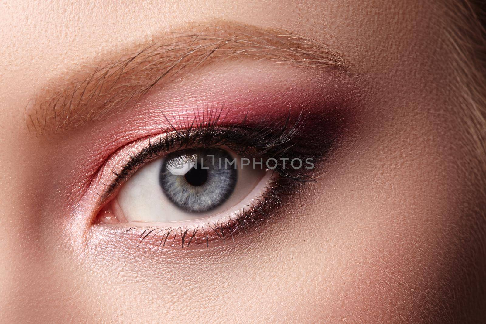 Closeup Macro of Woman Face with Eyes Make-up. Fashion Celebrate Makeup, Glowy Clean Skin and Natural Eyebrows. Summer Pink and black Eyeshadows