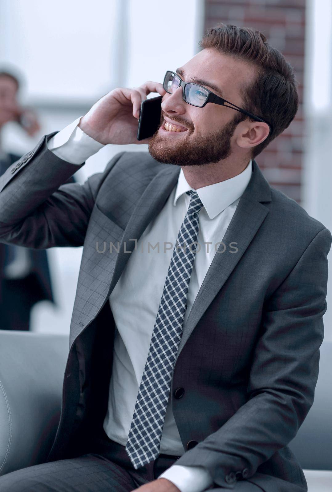 Charming businessman talking on phone in a modern building by asdf
