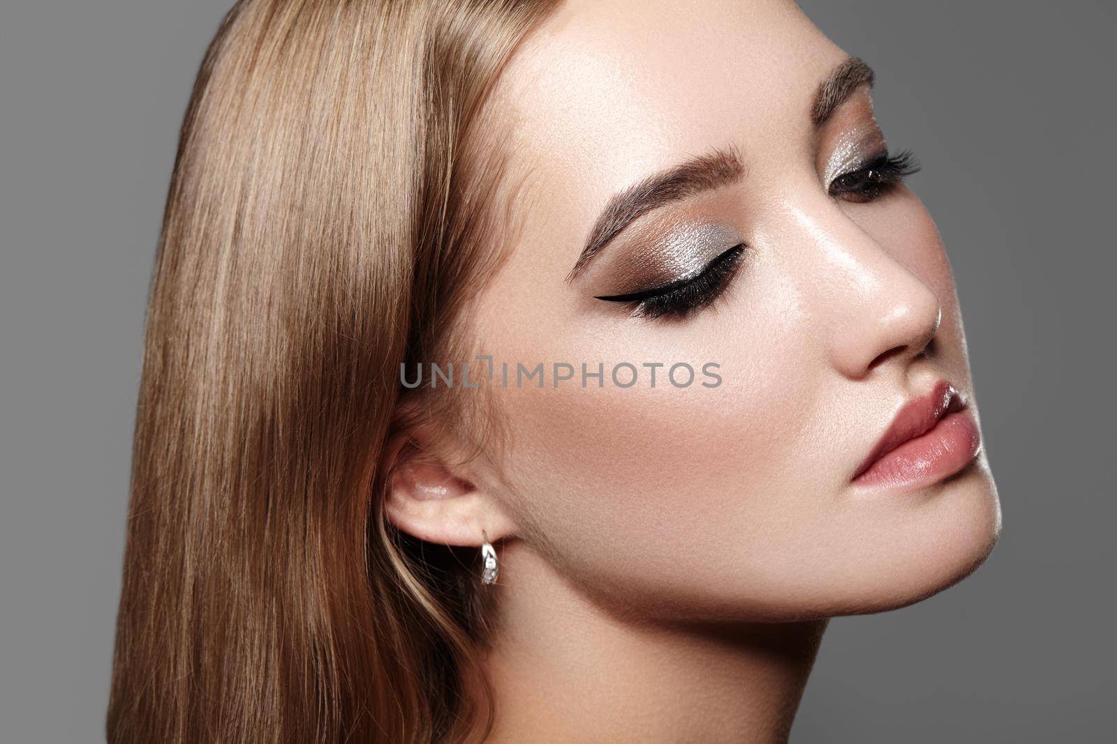 Beautiful Woman with Professional Makeup. Celebrate Style Eye Make-up, Perfect Eyebrows, Shine Skin. Bright Fashion Look. Black Liner, Shimmer Powder and Silver Eyeshadows