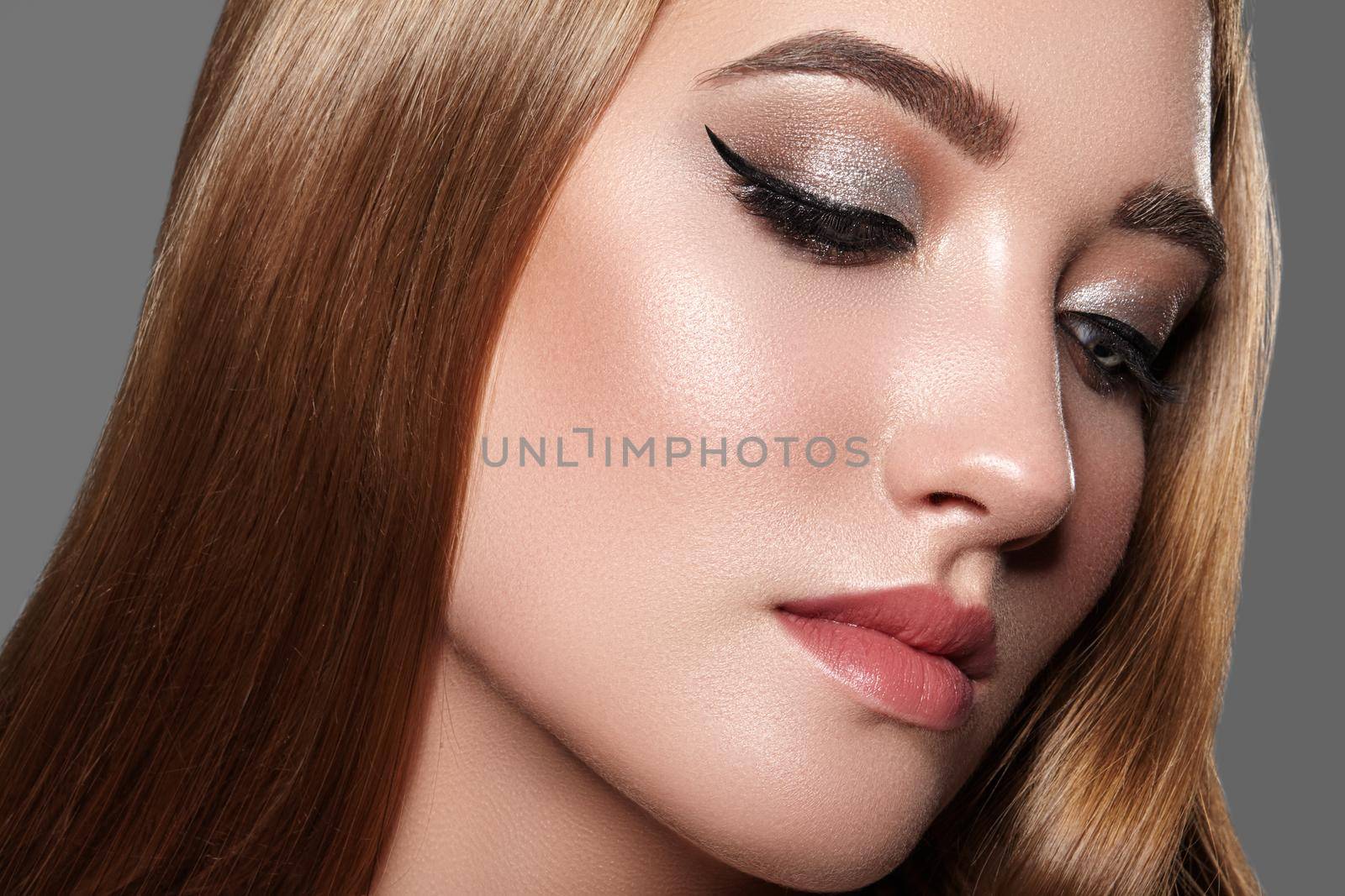 Beautiful Woman with Professional Makeup. Celebrate Style Eye Make-up, Perfect Eyebrows, Shine Skin. Bright Fashion Look. Black Liner, Shimmer Powder and Silver Eyeshadows