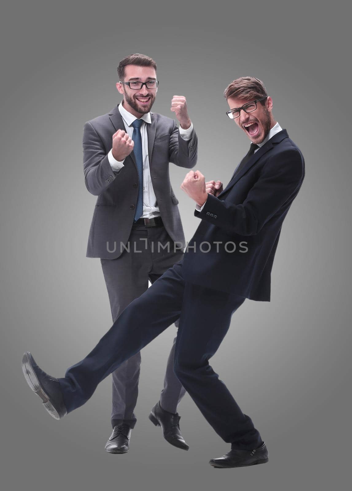 in full growth. two happy dancing young businessmen . isolated on white background.