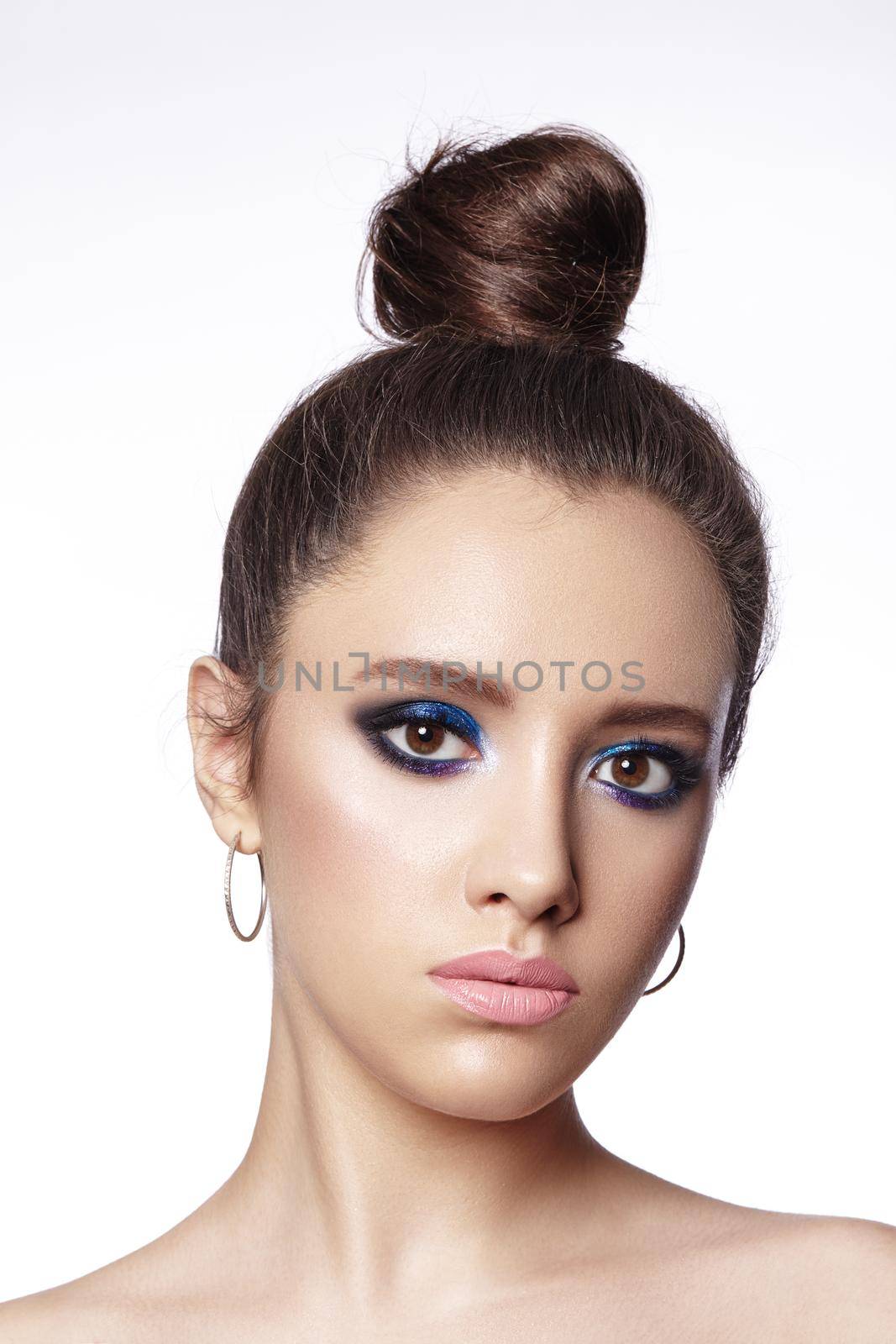 Beautiful Brunette Woman with Fashion Makeup and Bun Hairstyle. Celebrate Style Eye Make-up. Bright Fashion Look.