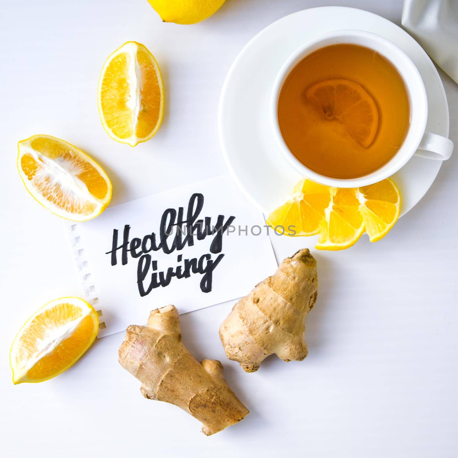 HEALTHY LIVING - written on piece of paper among the products for the treatment of common cold - lemon, ginger, chamomile tea. Vitamin natural drink. Cinnamon anise star.