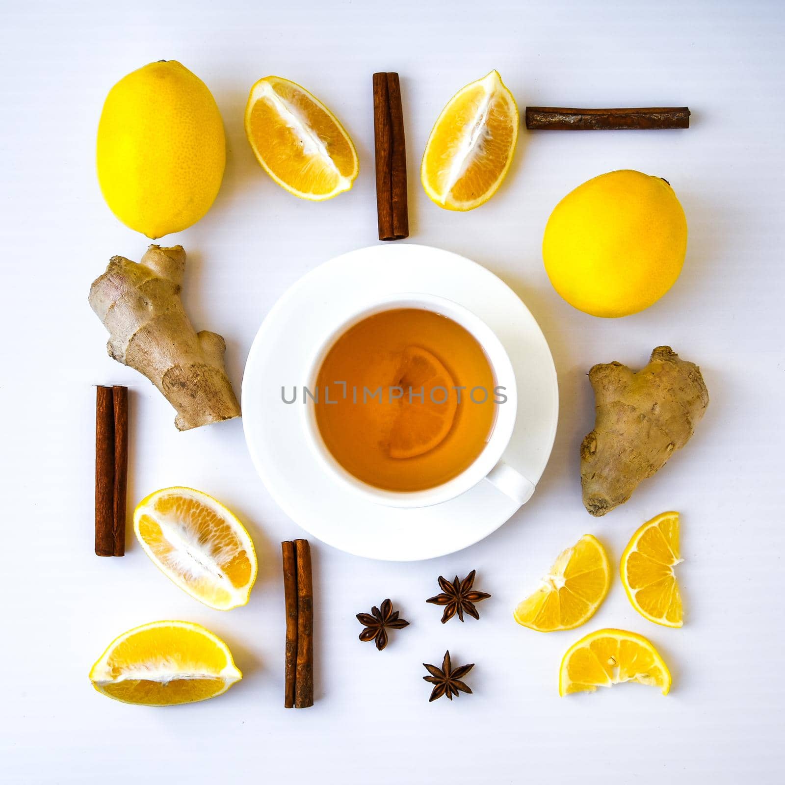 Trendy flat lay Ginger hot immunity boosting Vitamin natural drink With citrus lemon cinnamon anise in a rustic style on white background. Chamomile tea. by anna_stasiia