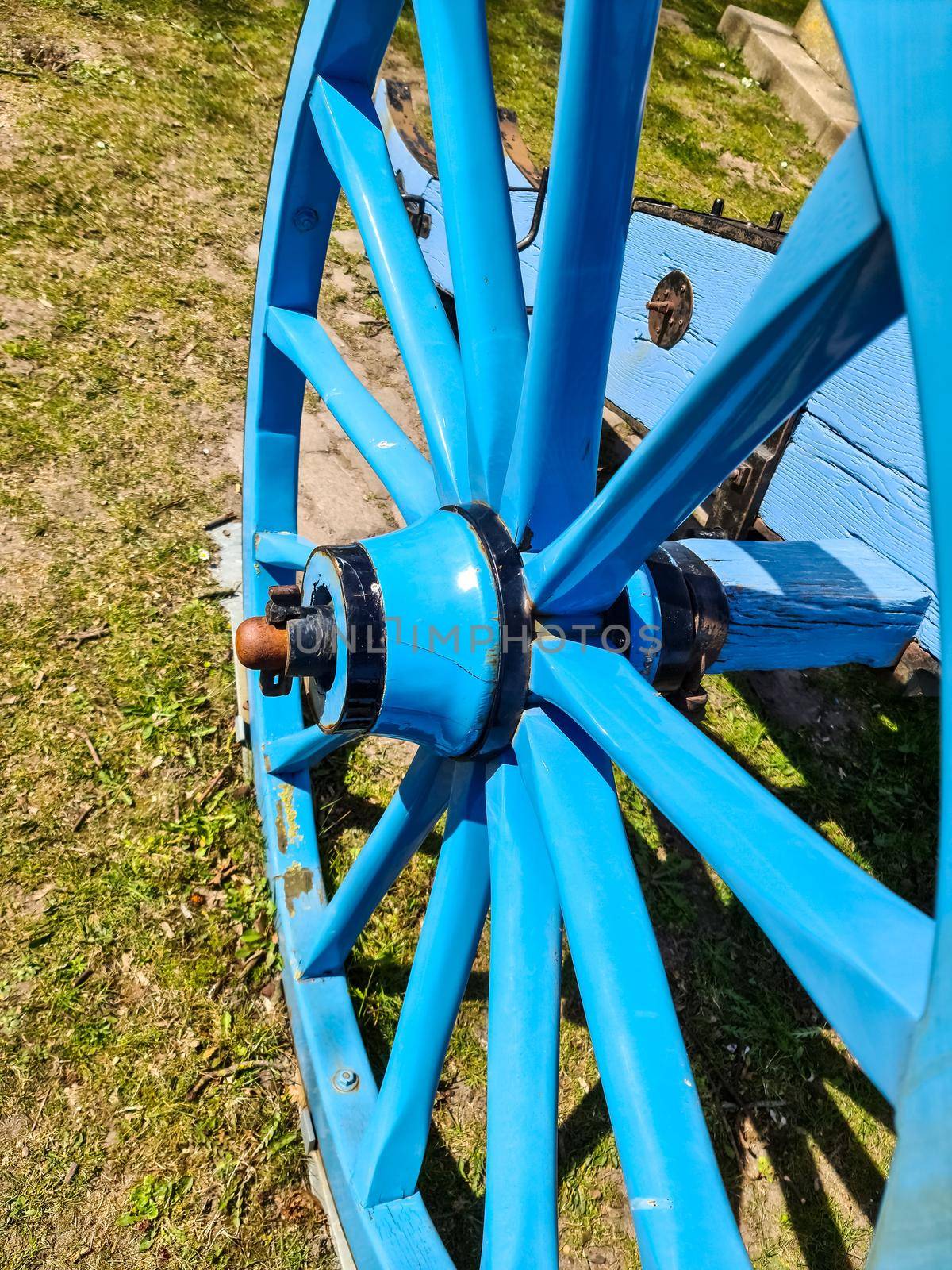 An old wooden wagon wheel in blue paint