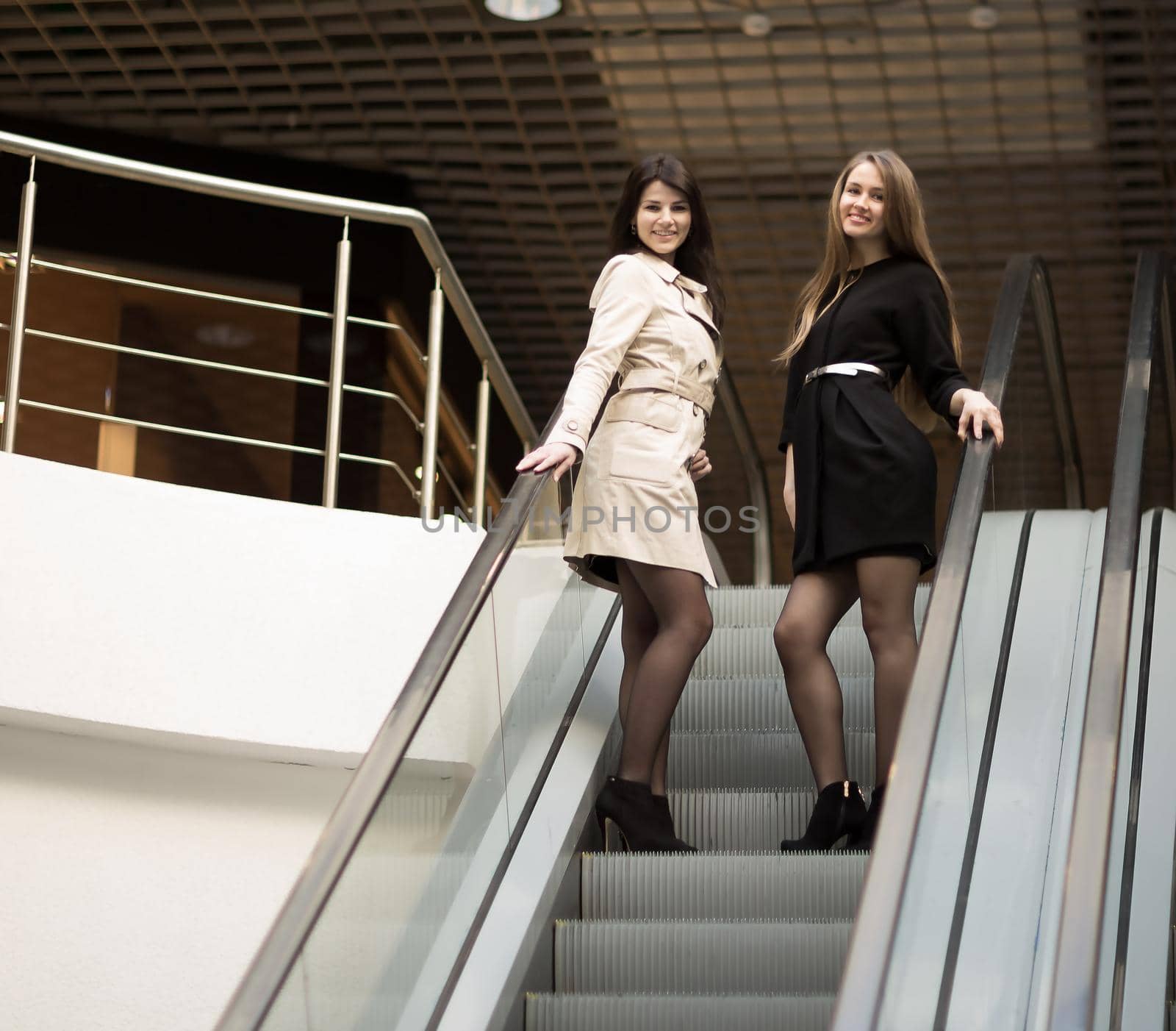 Employees of the company meet the client on the stairs in the foyer of the modern office.