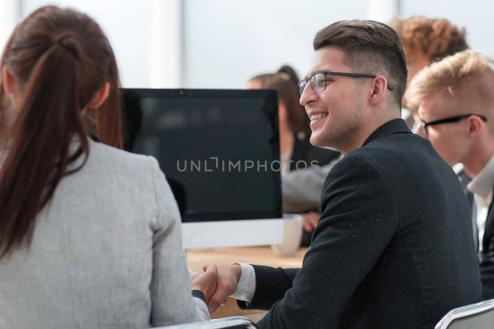 young businessman sitting among his colleagues at a meeting. the concept of teamwork