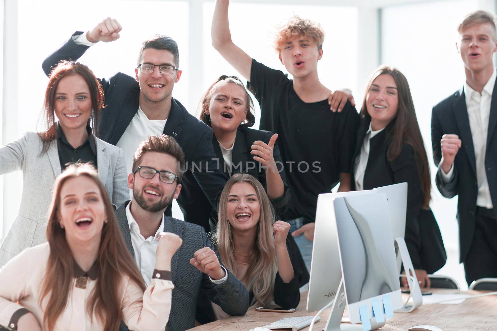 close up. a jubilant business team is cheering near the desktop. by asdf