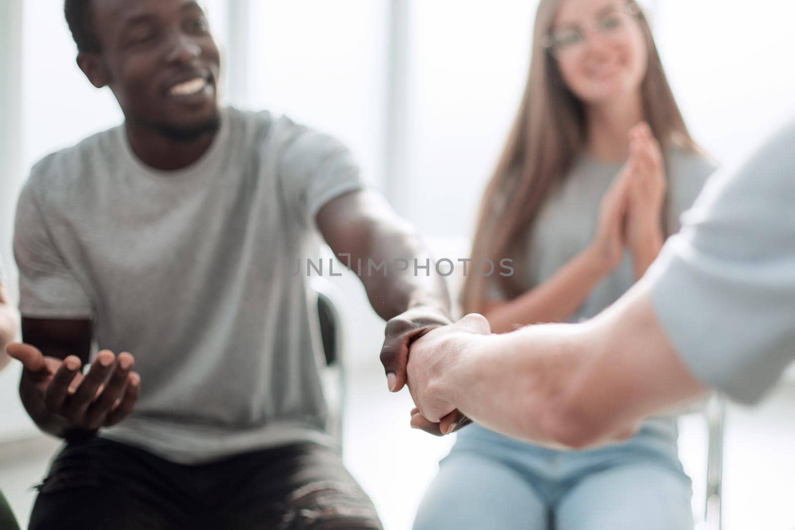 close up. smiling guy shaking hands with his friend. photo with space for text
