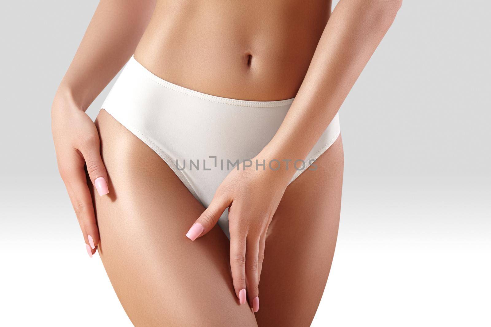 Spa and wellness. Healthy slim body in white panties. Beautiful sexy hips with clean skin. Fitness or plastic surgery. Perfect buttocks without cellulite.
