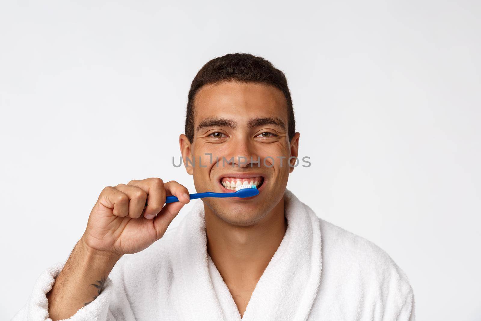 Man with tooth brush. African man holding a toothbrush with tooth brush and smiling while standing over white background. by Benzoix